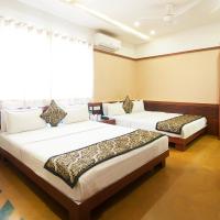 a hotel room with two beds and a flat screen tv at Uddhav Vilas A Family Hotel, Udaipur