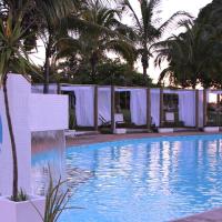 a swimming pool with a palm tree and white tents at Mar Doce Boutique Hotel, Três Marias