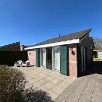 Knusse bungalow met omheinde tuin met veranda، فندق في Tzummarum