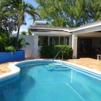 a swimming pool in front of a house at Coral Villa, Saint Philip