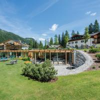 a resort with a large yard with a building at Hotel Dolomitenhof & Chalet Alte Post, Sesto