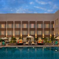 a hotel with a swimming pool in front of a building at Park Inn By Radisson Amritsar Airport