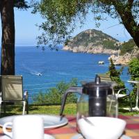 a table with a tea pot on it with a view of the ocean at Anna Pension, Liapades
