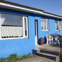 a blue house with a window and a chair at CJA Guesthouse, Laugar