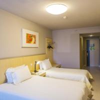 a hotel room with two beds and a tv at Jinjiang Inn Kunshan Renming Road West Street