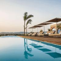 a swimming pool with lounge chairs and palm trees at Hotel Sahrai, Fez