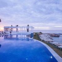 a swimming pool in front of a house and the ocean at La Badira - Adult Only, Hammamet