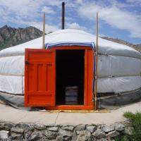 a large dome tent with a door in a field at My Mongolia Eco Ger Camp, Nalayh