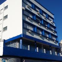 a building with blue balconies on the side of it at Hotel Obino, São Gabriel