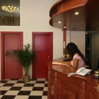 a woman sitting at a counter with a phone at Hotel Palladion, Ermoupoli