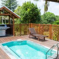 a swimming pool on a wooden deck with a grill and a picnic table at Hideaway Retreat, Burnt Pine