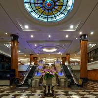 a lobby with a stained glass window and escalators at Seri Pacific Hotel Kuala Lumpur