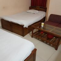 a room with two beds and a couch and a table at Hotel Diamond Park, Chittagong