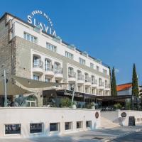a large white building with a sign on it at Grand Hotel Slavia, Baška Voda
