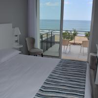 a bedroom with a bed and a view of the ocean at Hôtel Valencia, Hendaye