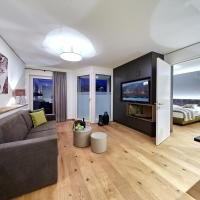 a living room with a couch and a tv at TWO TIMEZ - Boutique Hotel, Zell am See