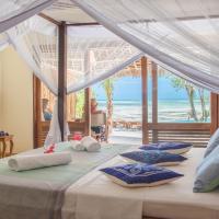 a bedroom with two beds with a view of the ocean at Marafiki Bungalows, Kiwengwa