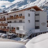 a building with cars parked outside of it in the snow at Hotel Mathiesn, Obergurgl