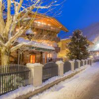a house on a snowy street with a tree at Hotel Garni Landhaus Platzer, Zell am Ziller