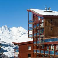 a hotel with snow covered mountains in the background at Résidences quartier Charmettoger - maeva Home, Arc 1800