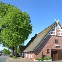 an old red brick building with a thatched roof at Landhotel Zur Eiche, Buxtehude