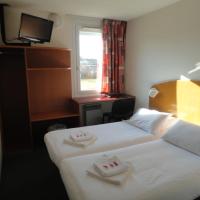 a hotel room with two beds and a window at Quick Palace Epinal, Épinal