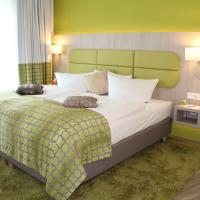 a bedroom with a large bed with a green headboard at Hotel Am Kaisersaal, Erfurt