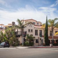 a building on the corner of a street with palm trees at La Casa Del Camino, Laguna Beach