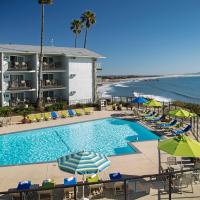a pool with chairs and umbrellas next to the beach at Shore Cliff Hotel, Pismo Beach