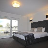 a bedroom with a bed and a large window at Quays Hotel, Batemans Bay