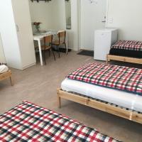 a room with three beds and a table at Hostel Finnmyrten, Juoksengi