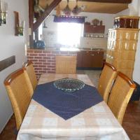 a table with chairs and a kitchen in a room at Chalupa Anton, Horní Halže