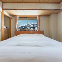 a bedroom with a white bed and a window at Hakuba Panorama Hotel