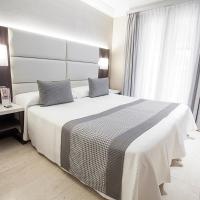 a bedroom with a large white bed and a window at Sercotel Europa, Pamplona