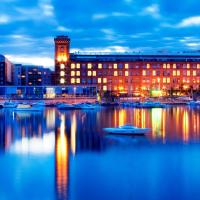a large building with boats in the water at night at Holiday Club Tampereen Kehr&auml;&auml;m&ouml;