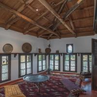 a large living room with a table and windows at Urania Traditional Stone House, Pinakátai