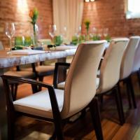 a long table with white chairs and wine glasses at Hotel Navigare, Buxtehude