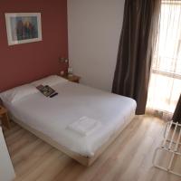 a small bedroom with a white bed and a window at Hotel Primo Colmar Centre