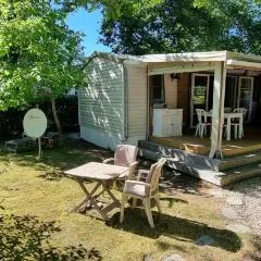 Mobile home avec terrasse et piscine.