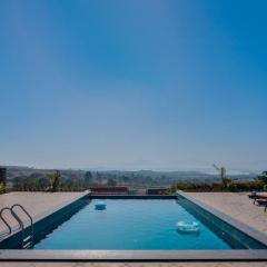 Breezy Whispers by StayVista - Private infinity pool, Stunning mountain views, Spacious swimming pool, Deck & Lawn