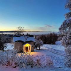 Mysigt hus med utsikt över fjäll och älv.