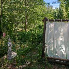 Tente dans gazébo thaï dans jardin en bord de rivière