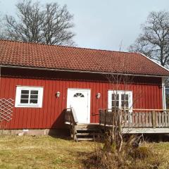 Cozy red cottage with white knots outside Lenhovda