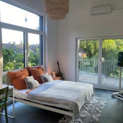 Helles Zimmer im modernen Holzhaus mit Queensize-Bett, Balkon, Schreibtisch, TV, Klimaanlage & abdunkelnden Jalousien