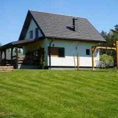 Domek z kominkiem nad jeziorem z jacuzzi ogrodowym