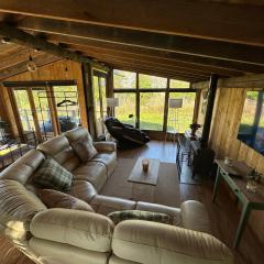 5 Star Country Retreat, huge Log Cabin over small river, with private hot tub & log burner, WiFi, 65 inch smart TV relax read at Weston Newark, Nottinghamshire