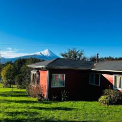 Casa con orilla de río y vista a los volcanes
