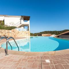 Complex surrounded by greenery with pool