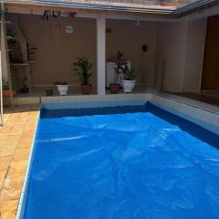 Casa inteira com três quartos, piscina aquecida por energia solar e área de churrasqueira