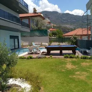 Bahce, barbeku ve cocuk oyun parkı olanağı ve buyuk bir havuzu olan geniş aileler için ideal